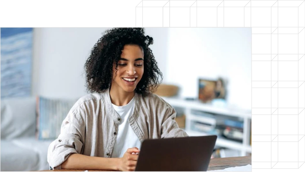 Photo of student smiling looking into a laptop.