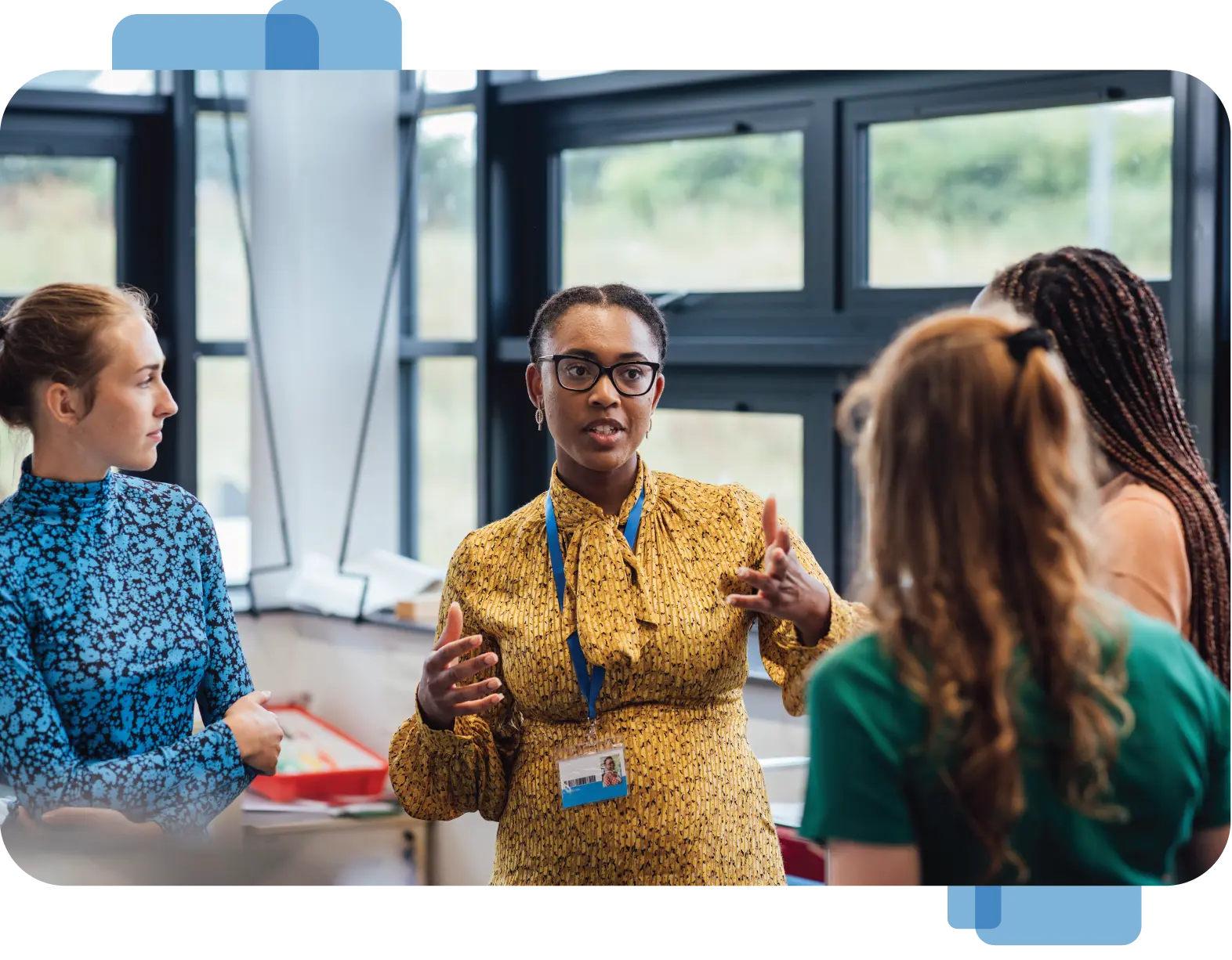 A teacher speaks with a group of three women.